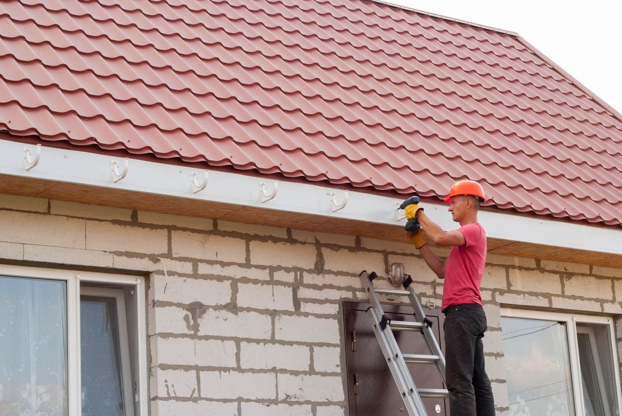 A man is working on a roof with a ladder.