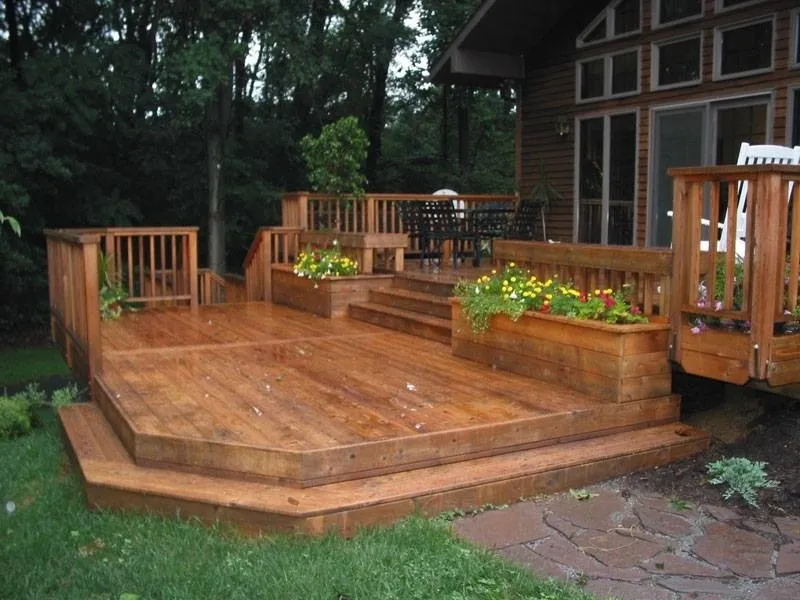 A wooden deck with flowers and stairs.