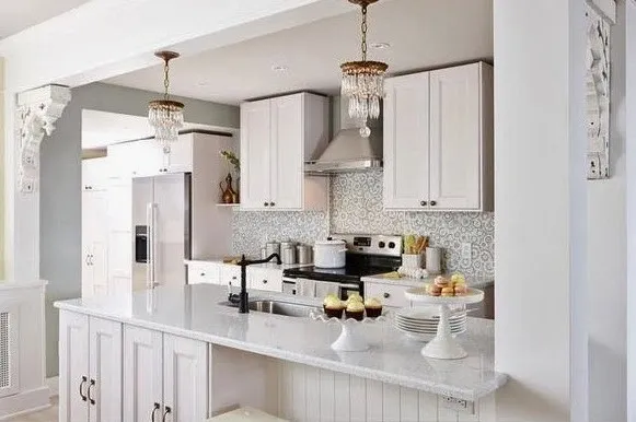A kitchen with white cabinets and a bar stools.